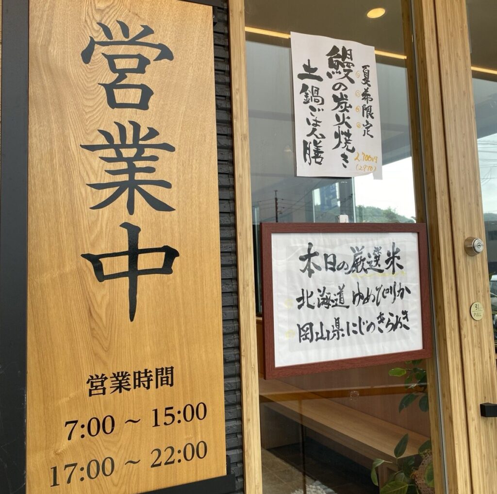 銀しゃりあぶりや水島店の入口。営業時間7時から15時と17時から22時の看板と本日の厳選米の掲示
