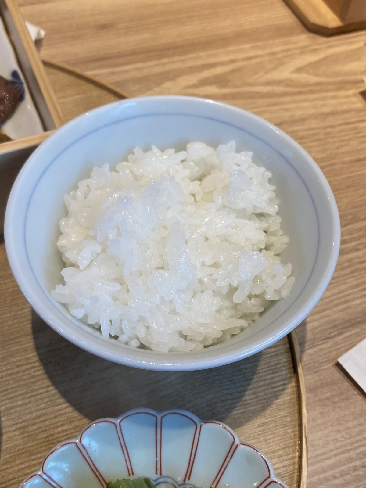 お茶碗によそわれた炊きたて土鍋ごはんのアップ。米粒がつややかに立っている