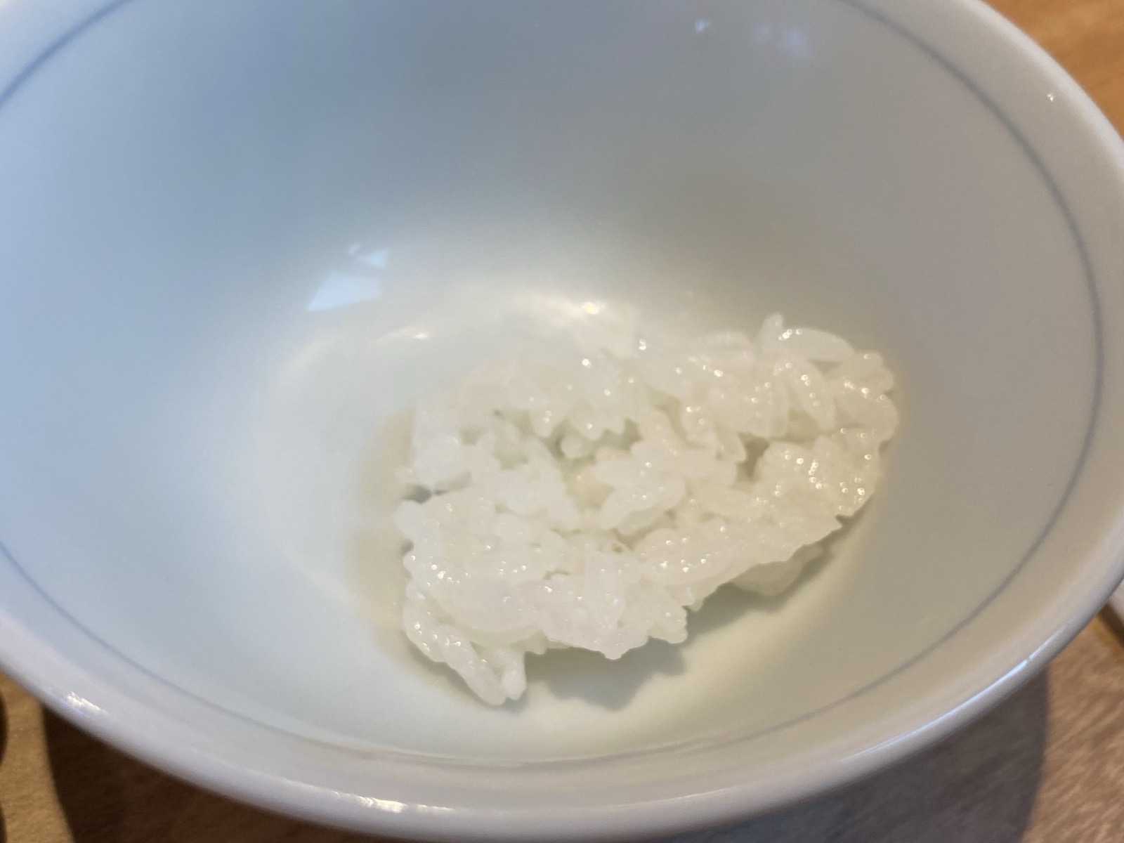 お茶碗によそわれた炊きたて土鍋ごはんの最初のひと口分