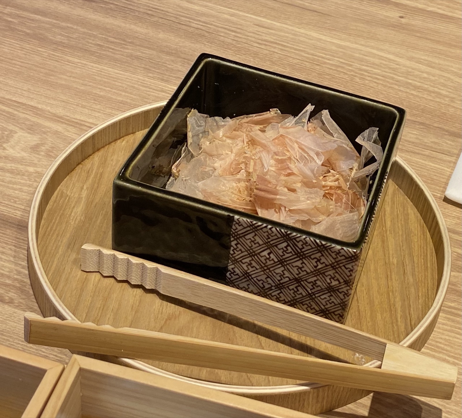 削りたての溶ける鰹節が入った器と木のトング