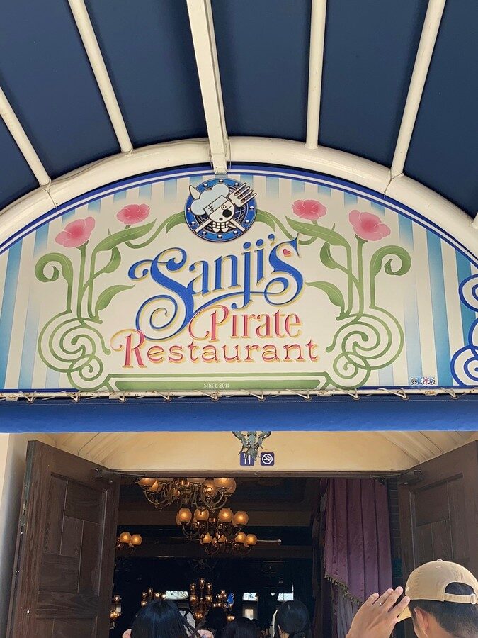 Sanji's Pirate Restaurantの看板がある入口から店内へ入っていく人たち